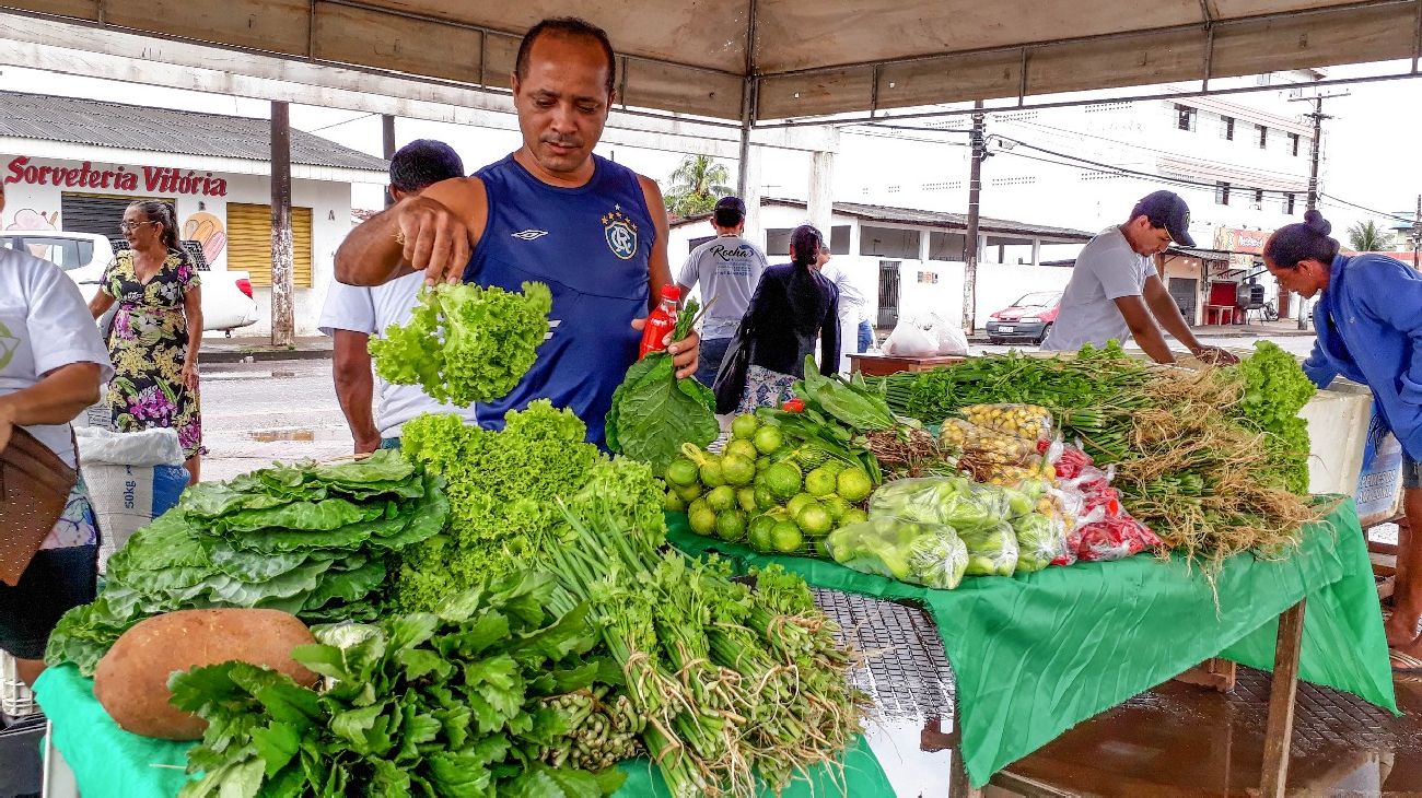 Agibson de Souza escolhe hortaliças na Feira Solidária realizada no bairro onde ele mora
