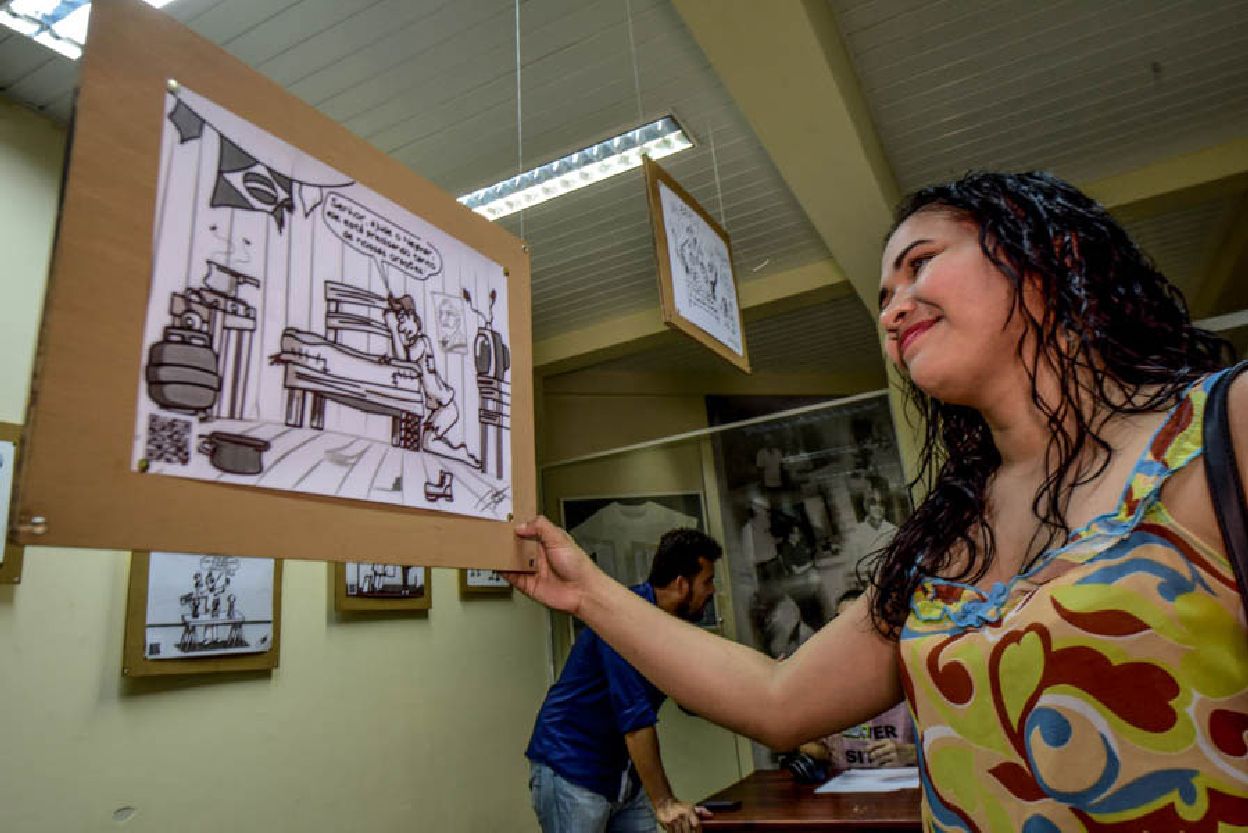 Jovem contempla imagem em exposição sobre as copas do mundo de futebol