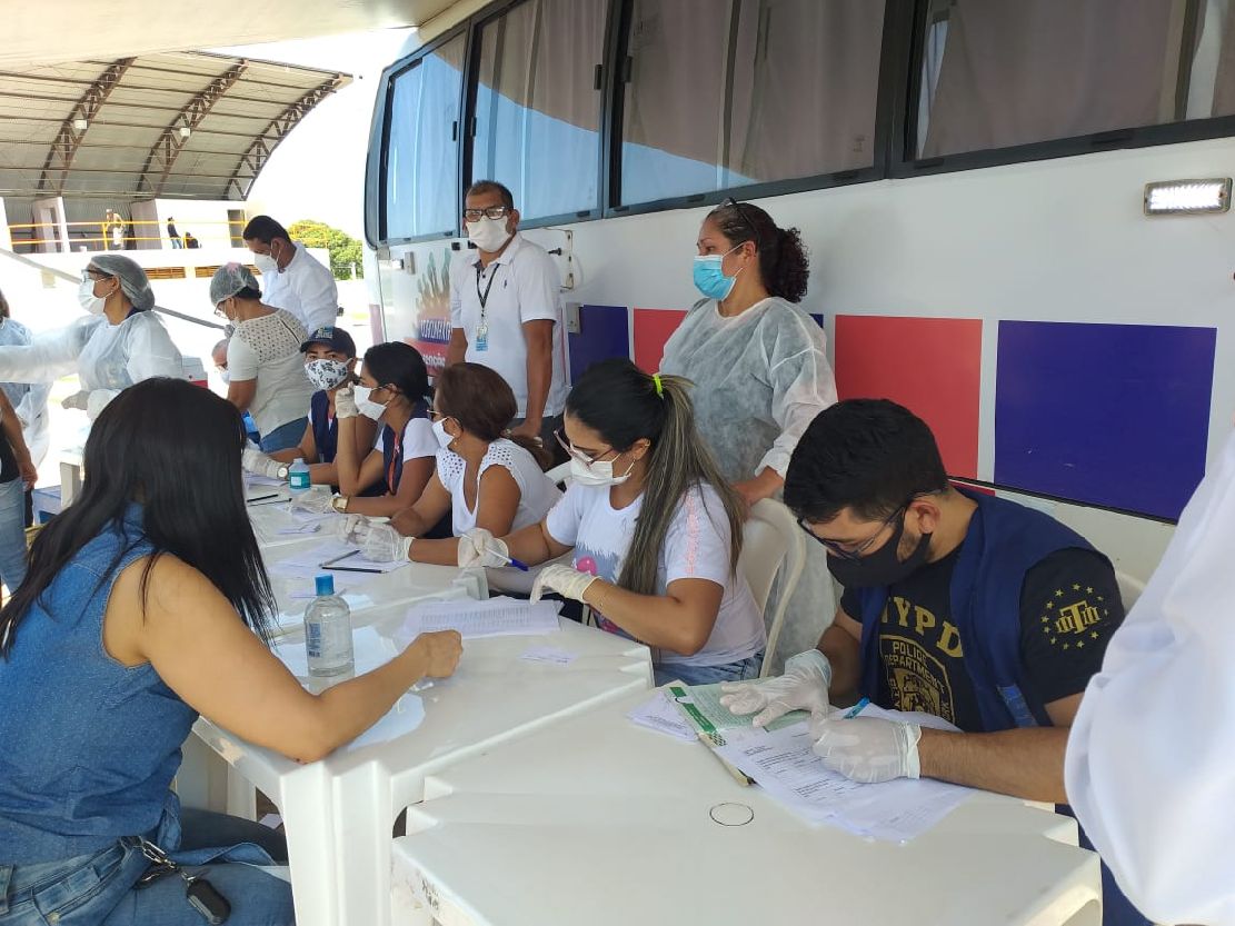 Equipe de agentes de técnicos e agentes da SVS realizando preenchimento da carteira de vacinação em Santana.