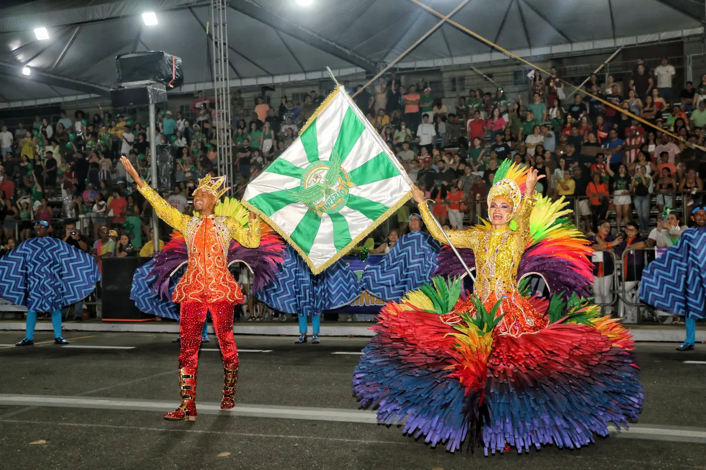 Casal de mestre-sala e porta-bandeira, com vestes reluzentes e luminescentes, esbanjaram harmonia na avenida