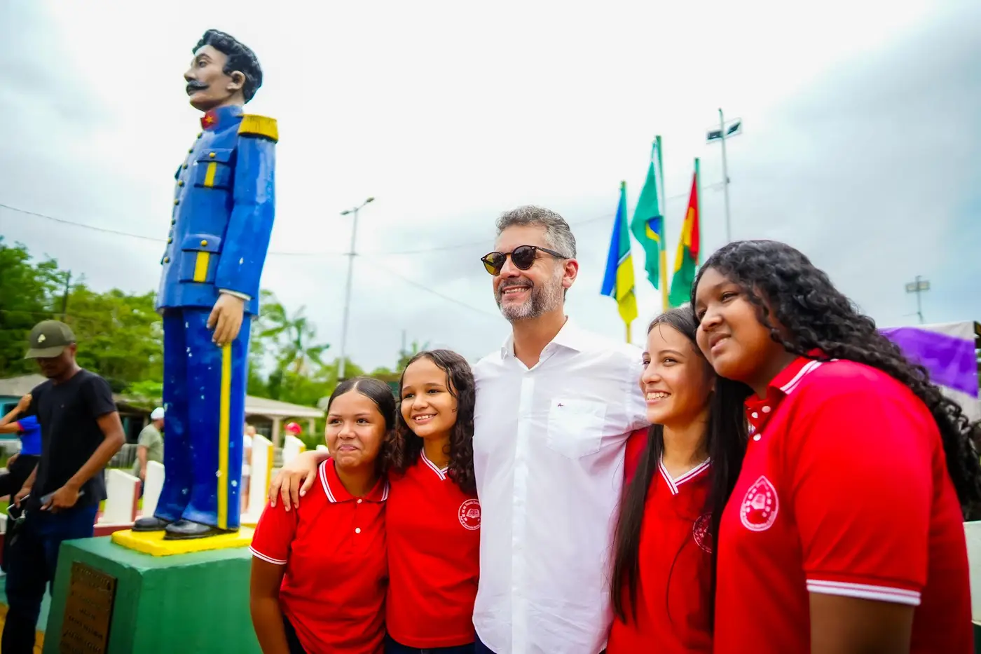Governador Clécio Luís abraçado com estudantes ao lado da estátua de Cabralzinho