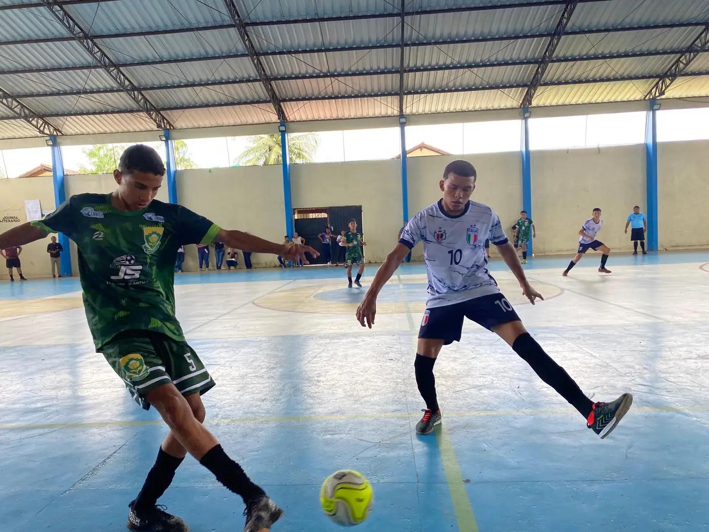 Equipes masculinas de futsal em ação durante os Jogos Escolares em Oiapoque, com disputas acirradas e forte participação estudantil