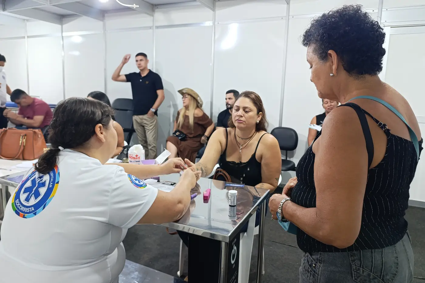 Gleice Alves, com a mãe Maria de Lourdes (em pé) recebendo atendimento médico no posto 2 da Expofeira