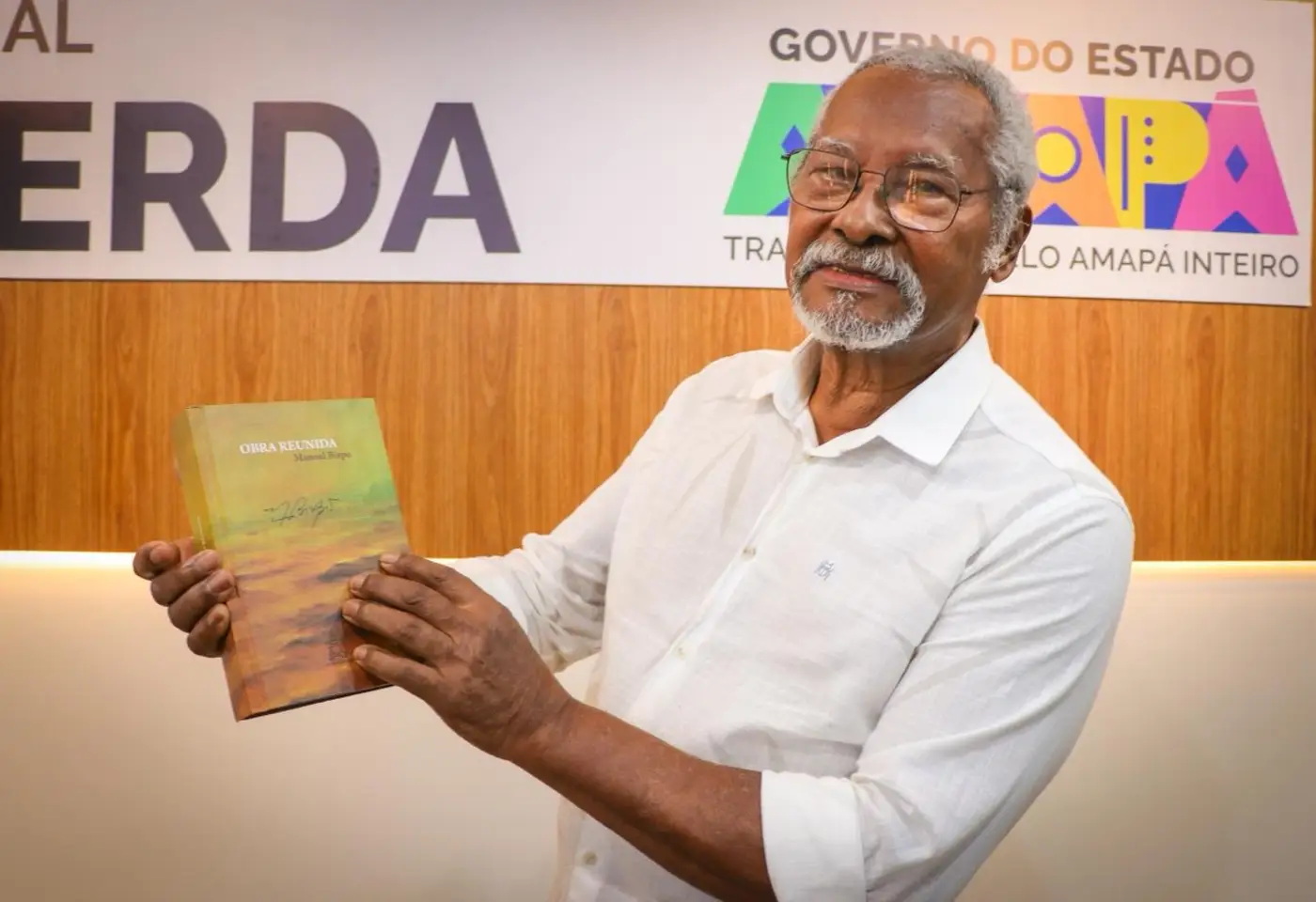 Escritor amapaense, Manoel Bispo mostra uma de suas obras durante cerimônia de reinauguração da Biblioteca Elcy Lacerda