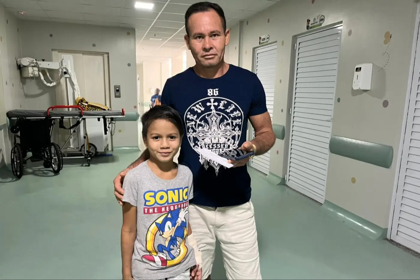 José Vitor, 8 anos e o pai Adelino Araújo comemoram a alta do garoto