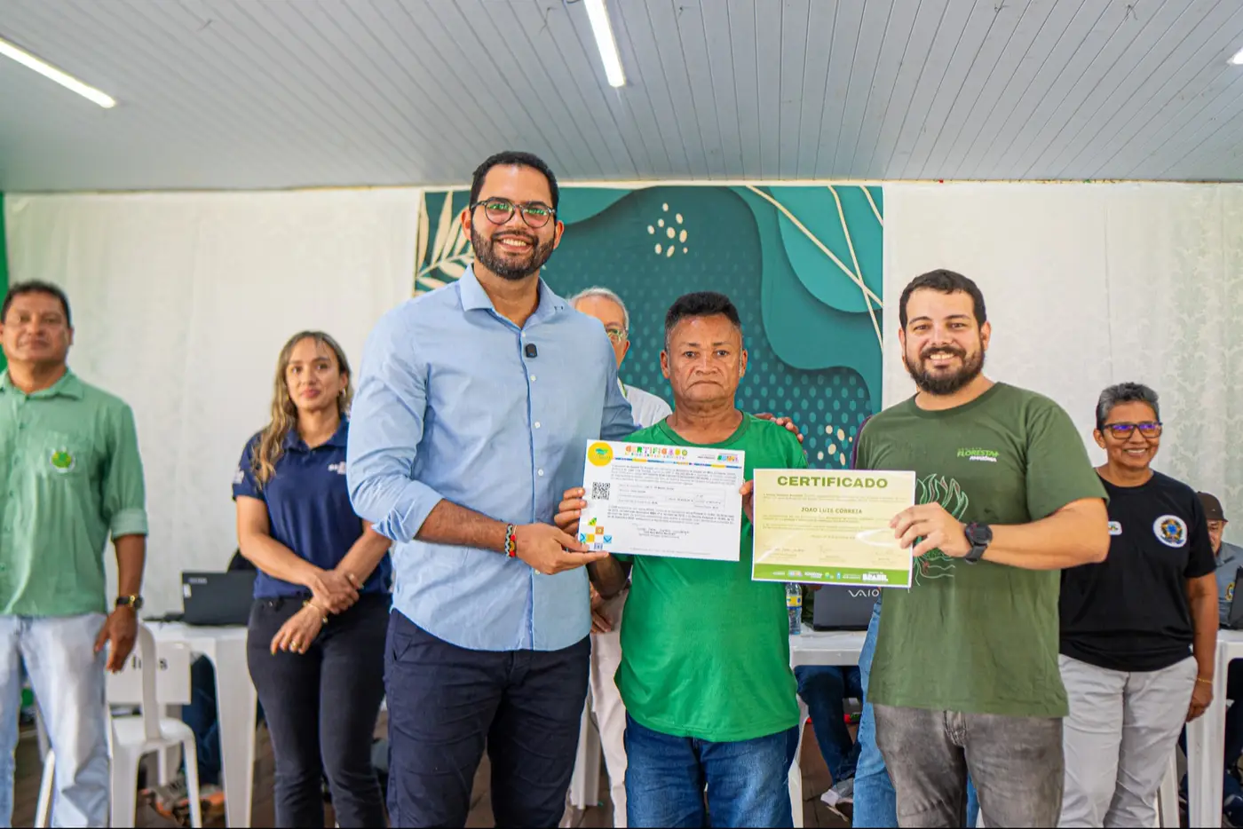O secretário adjunto da Sema, Cássio Lemos, e o coordenador local do Floresta+, Alan Góes, fazem entrega a agricultor