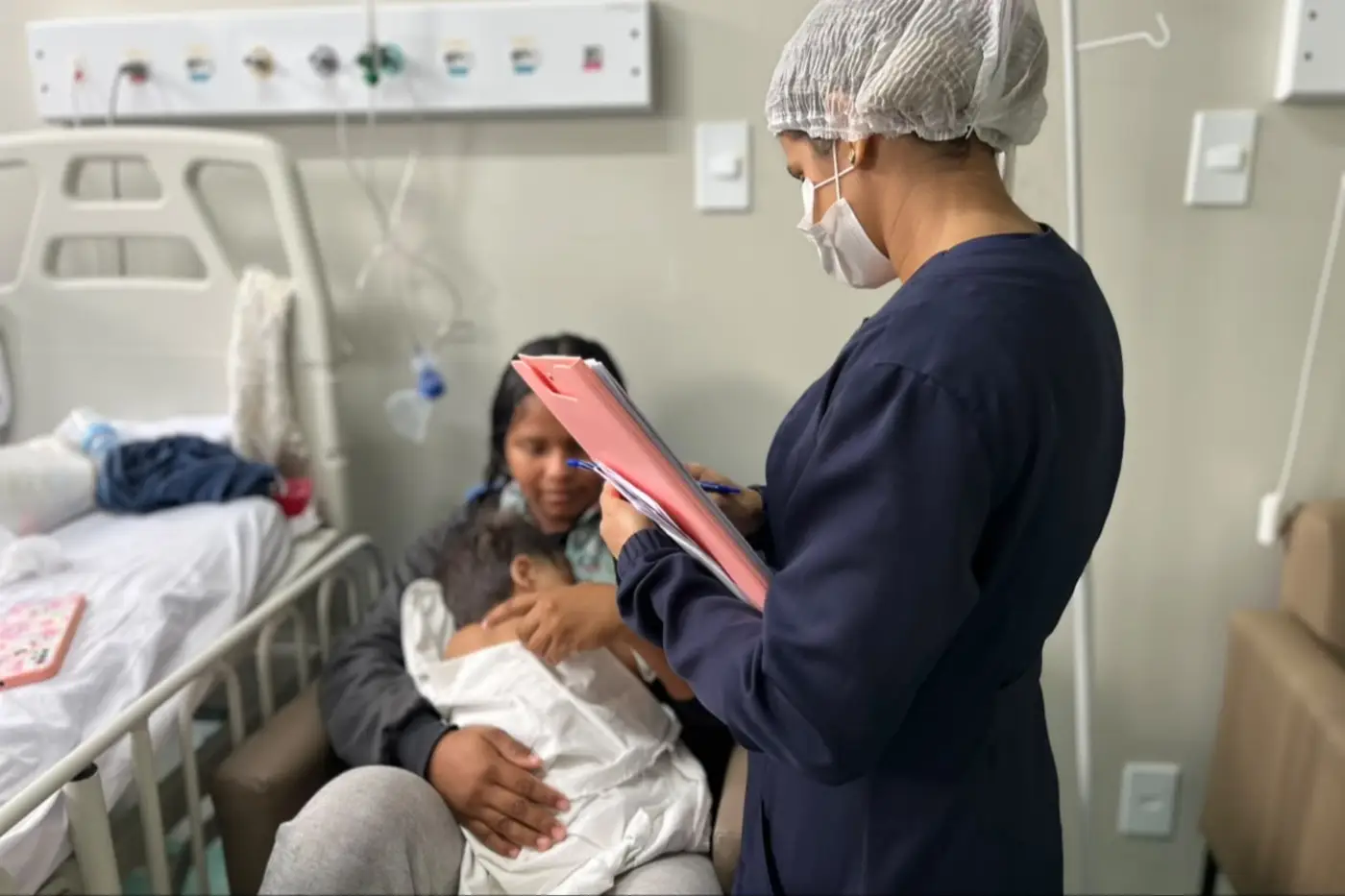 Equipa de saúde do HCA repassa instruções diretas à mãe acompanhante sobre os cuidados necessários para evitar a contaminação cruzada e proteger a criança durante a internação